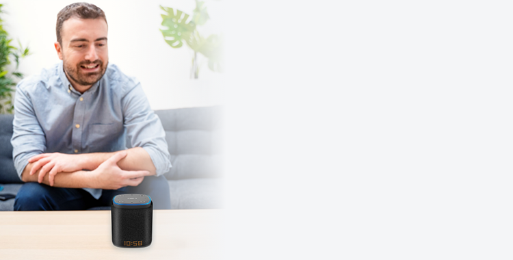 A man sitting at a table using iFORA IntelliSpeaker