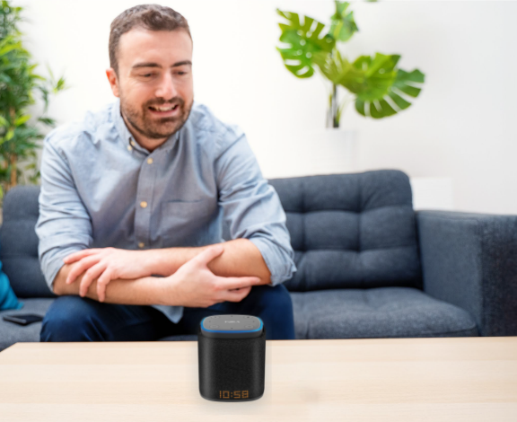 A man sitting at a table using iFORA IntelliSpeaker