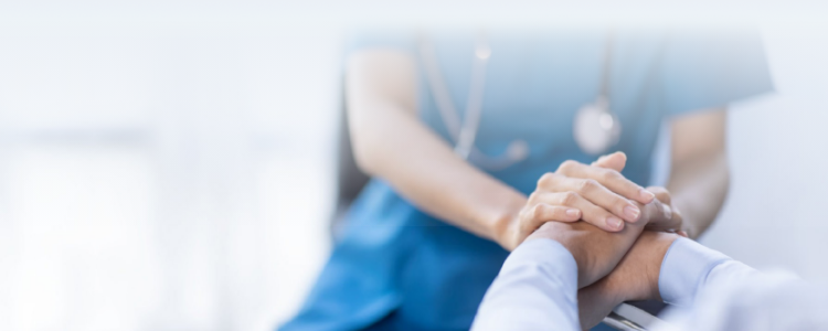 A caregiver holding the elder's hand