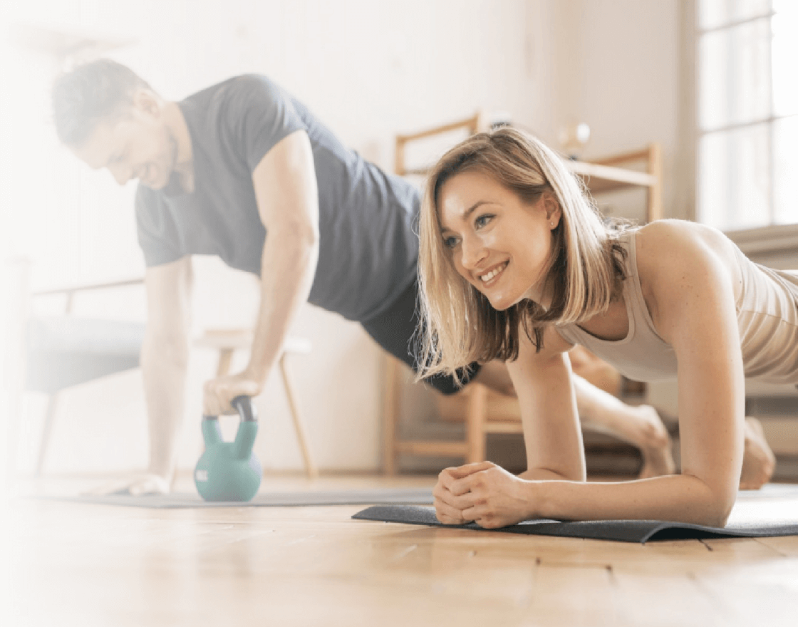 Two people doing core training on yoga mats at home