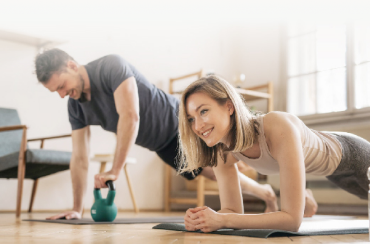 Two people doing core training on yoga mats at home