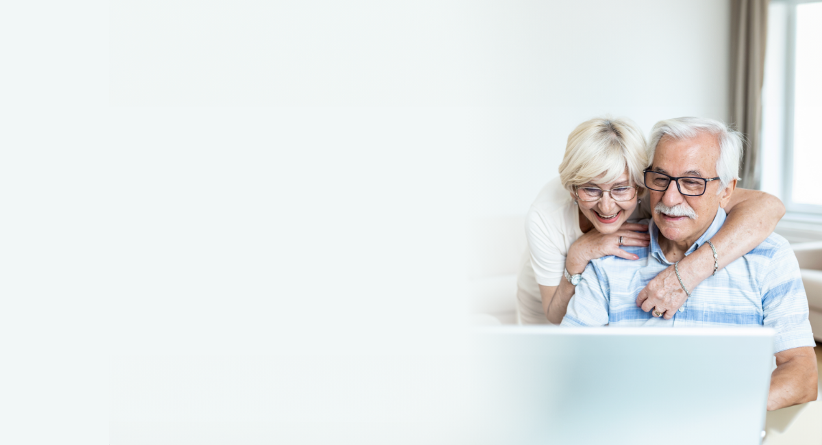 A smiling couple looking at a computer at home