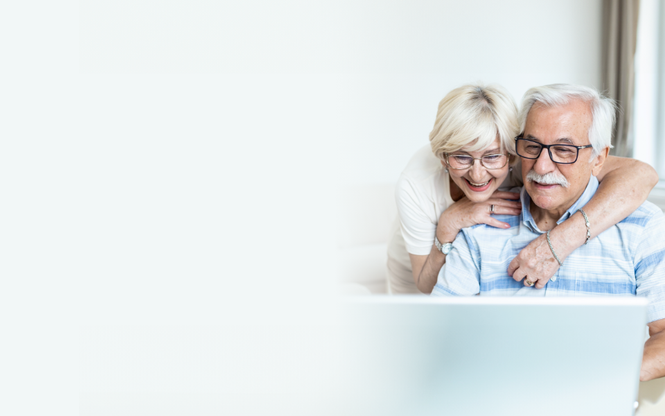 A smiling couple looking at a computer at home