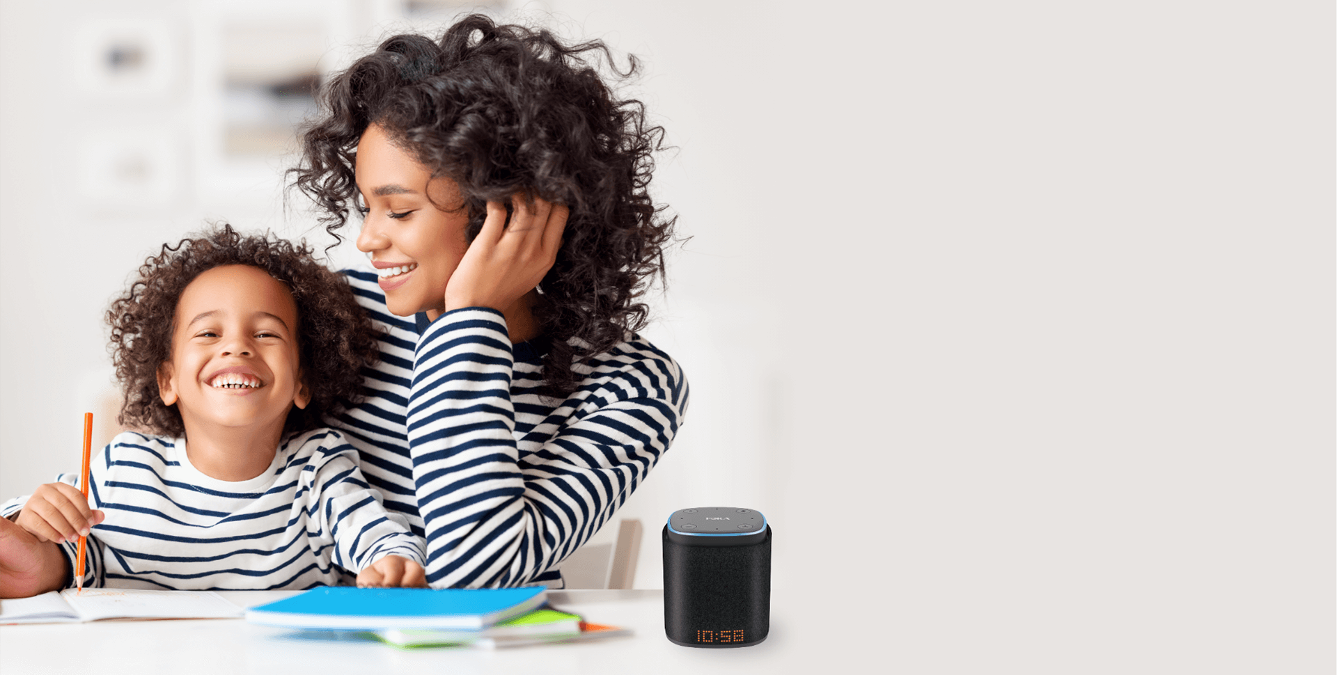 Mom accompanying her happy child drawing, with an iFORA IntelliSpeaker on the table