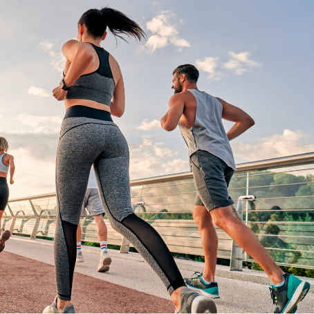 People jogging on a bridge at sunset