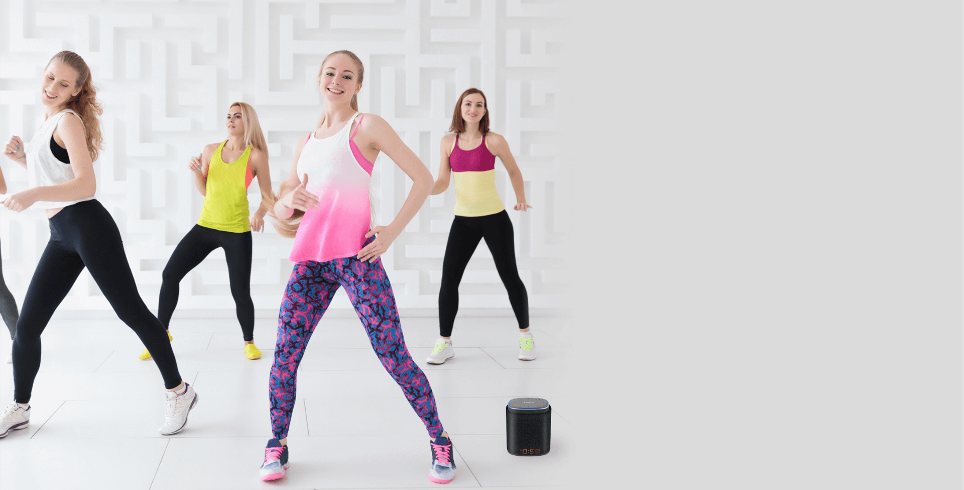 A group of women dancing next to an iFORA IntelliSpeaker