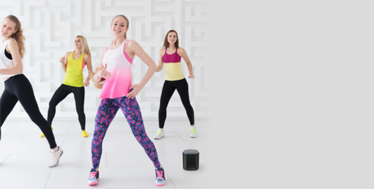 A group of women dancing next to an iFORA IntelliSpeaker