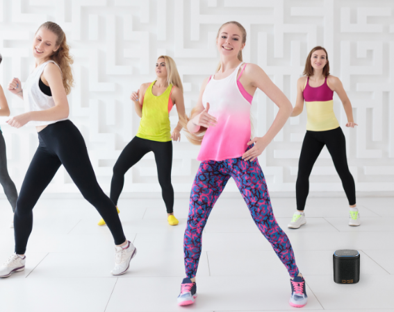 A group of women dancing next to an iFORA IntelliSpeaker