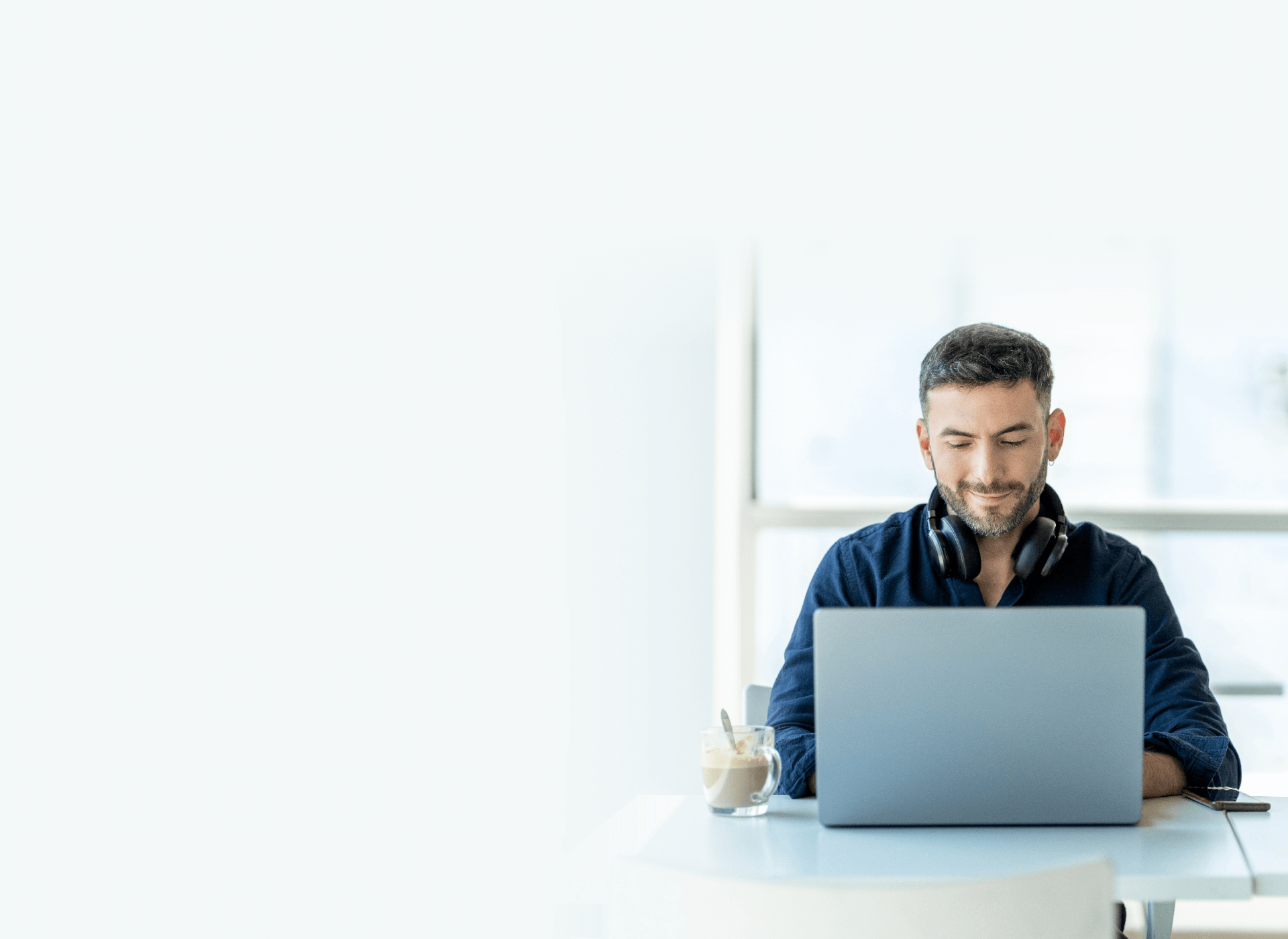 A man sitting at a table using a laptop