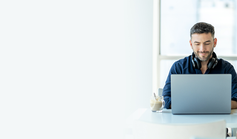 A man sitting at a table using a laptop