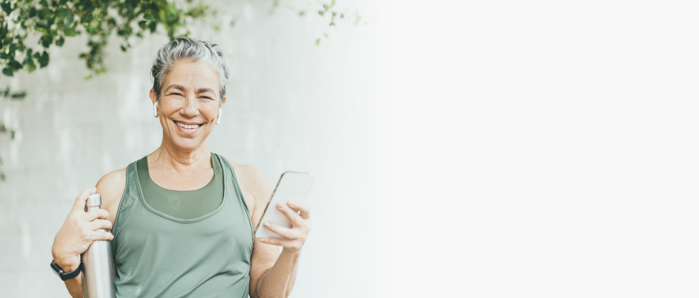 Healthy woman smiling, holding a water bottle and a smartphone