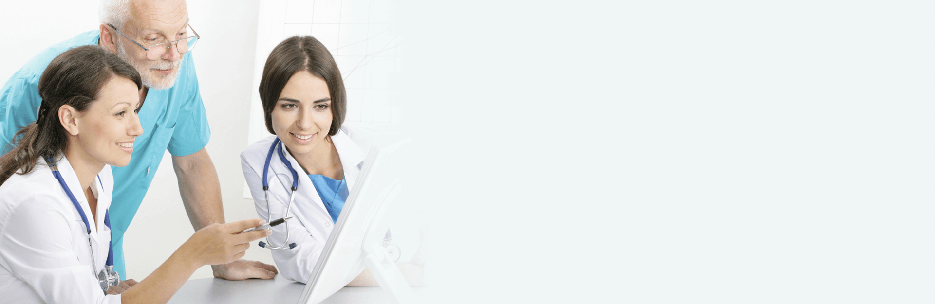 Physicians and patient looking at computer screen and discussing health