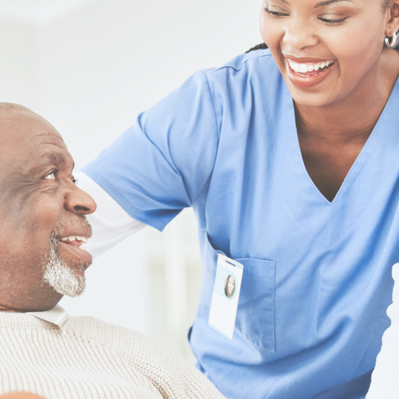 A smiling caregiver looking at elderly man, showing care and warmth