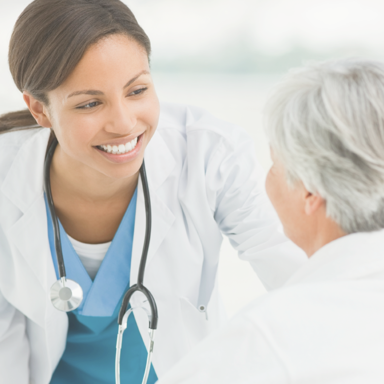 A smiling physician looking at an elderly woman, showing care and warmth