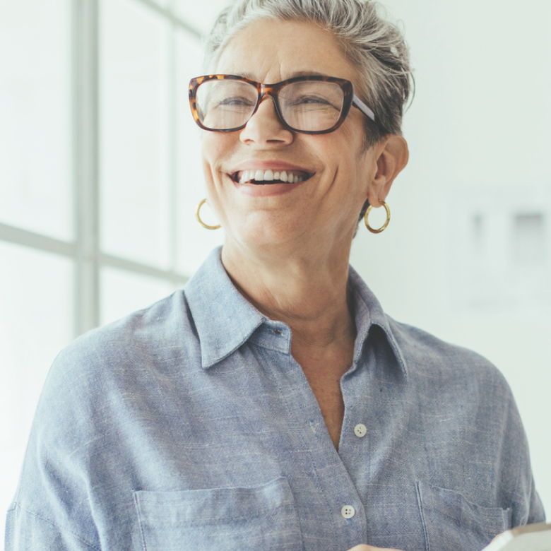 A happy woman holding a phone at home